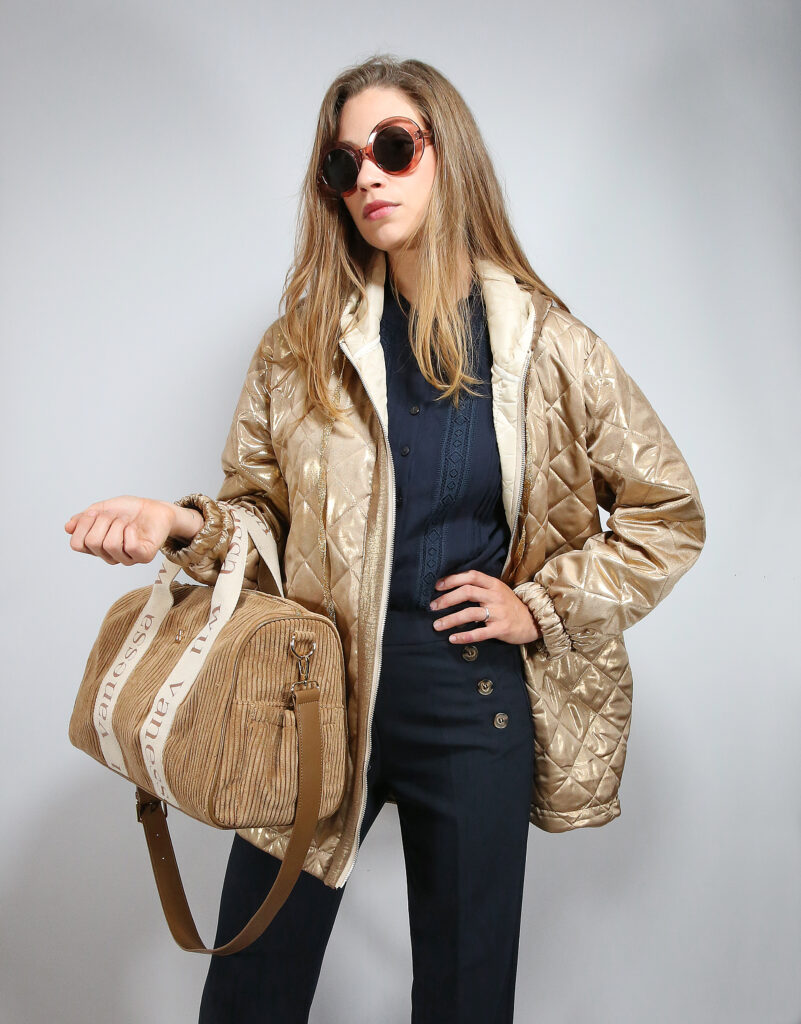 Jeune femme prise en photo dans un studio, avec des tenues mode : veste, pantalon, jean, blouse et sac à main.